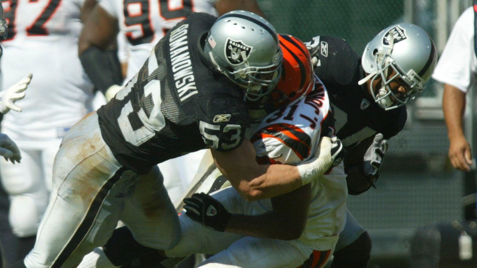 Bill Romanowski tackles a player while playing for the Oakland Raiders